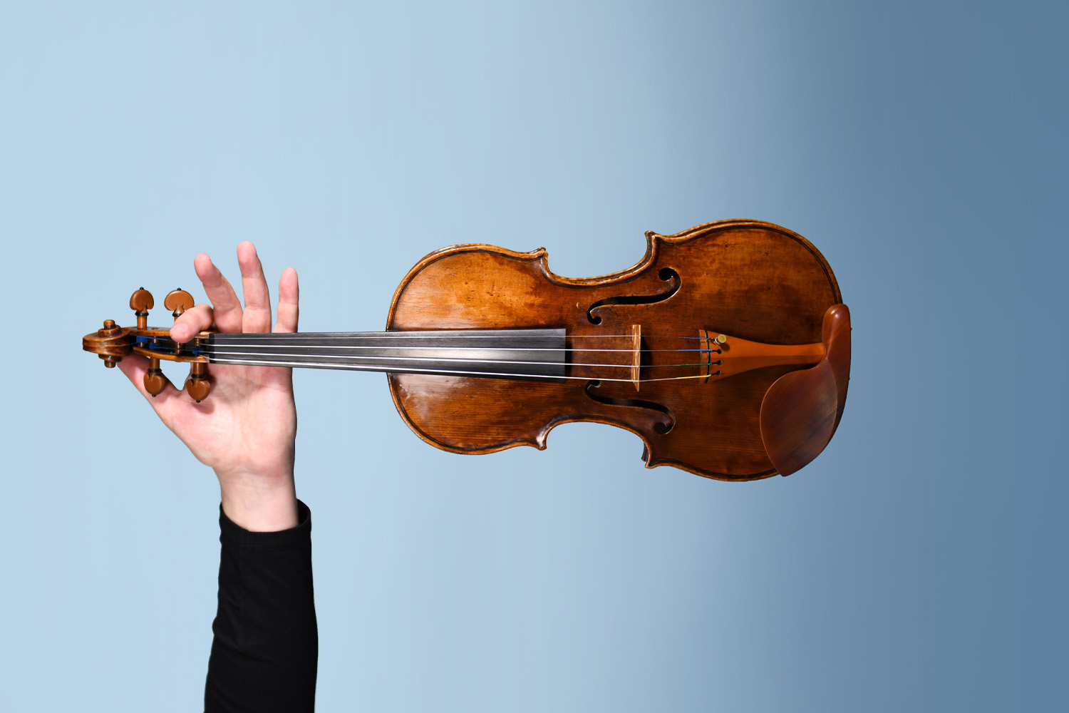 Hand holding violin. Photo by Giulia McGauran.