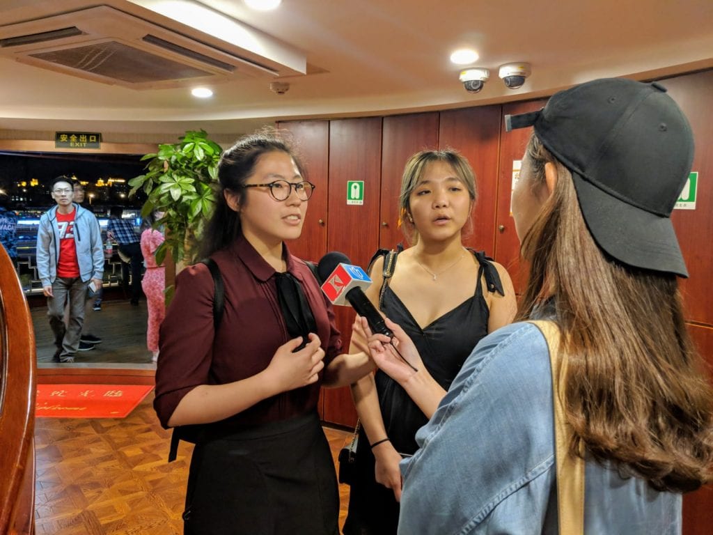 L-R: Pianist Danna Yun and horn player Rosemarry Yang discuss the University of Melbourne Symphony Orchestra Tour with a reporter from Shanghai’s Kankan TV Station. By Alix Bromley.