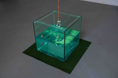 A fish tank filled with water suspended by a red rope