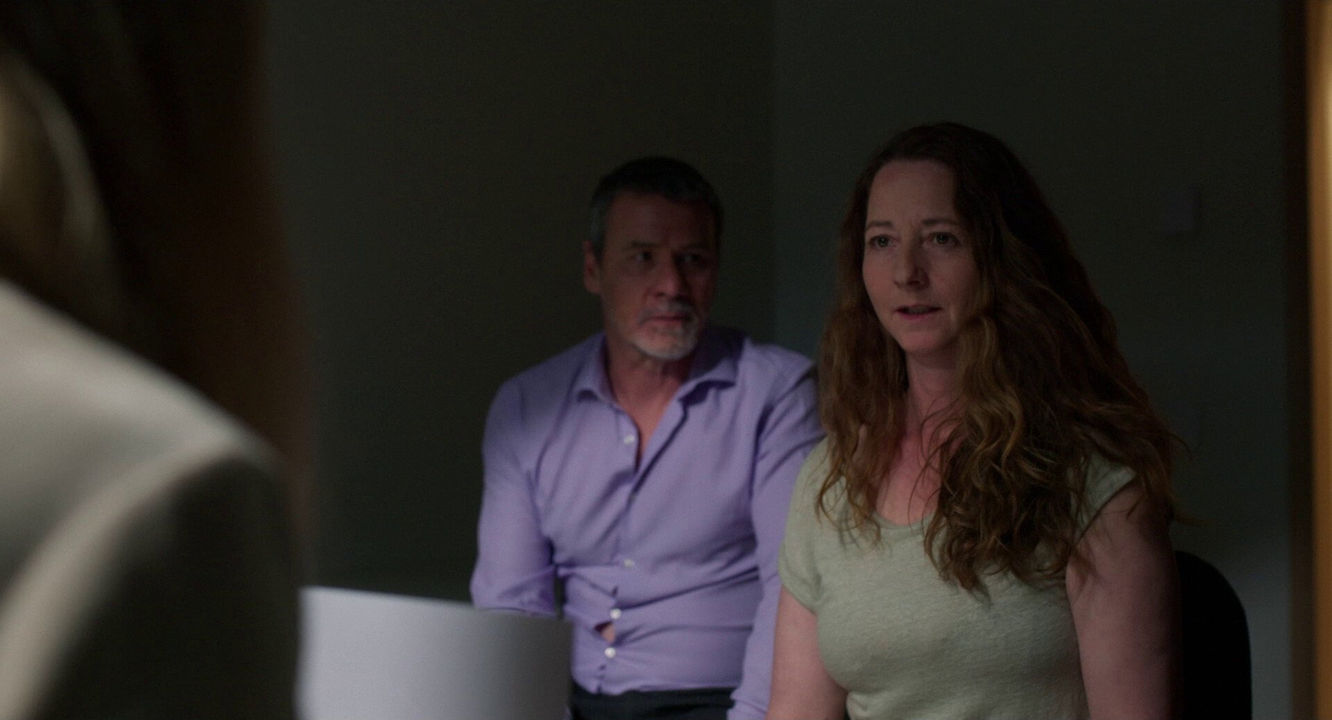A man and a woman in shadow sitting in a doctor's office