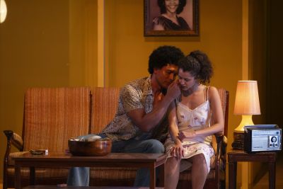 A man and a woman sit on a sofa