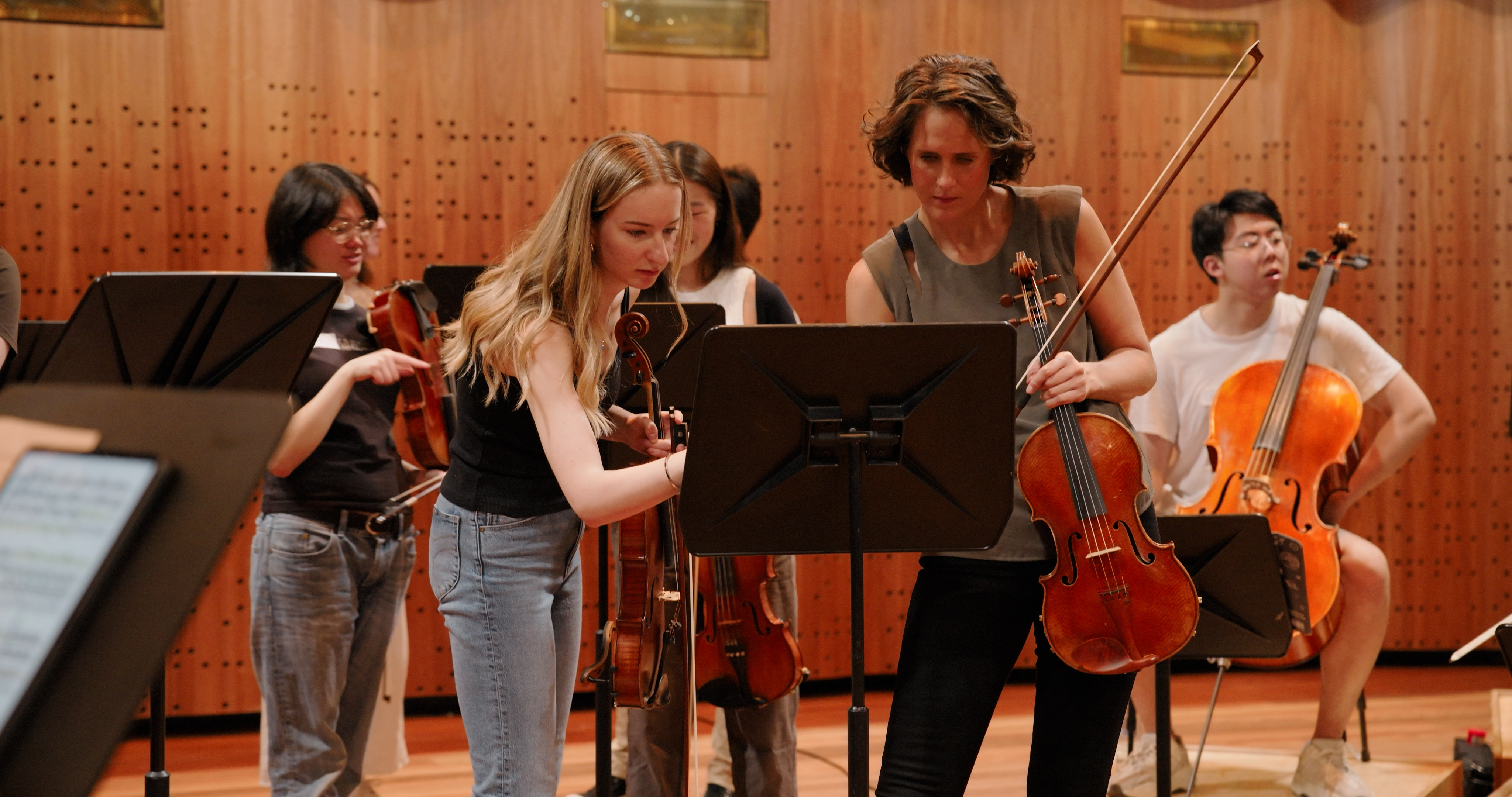 Musicians looking at a lecturn in an auditorium