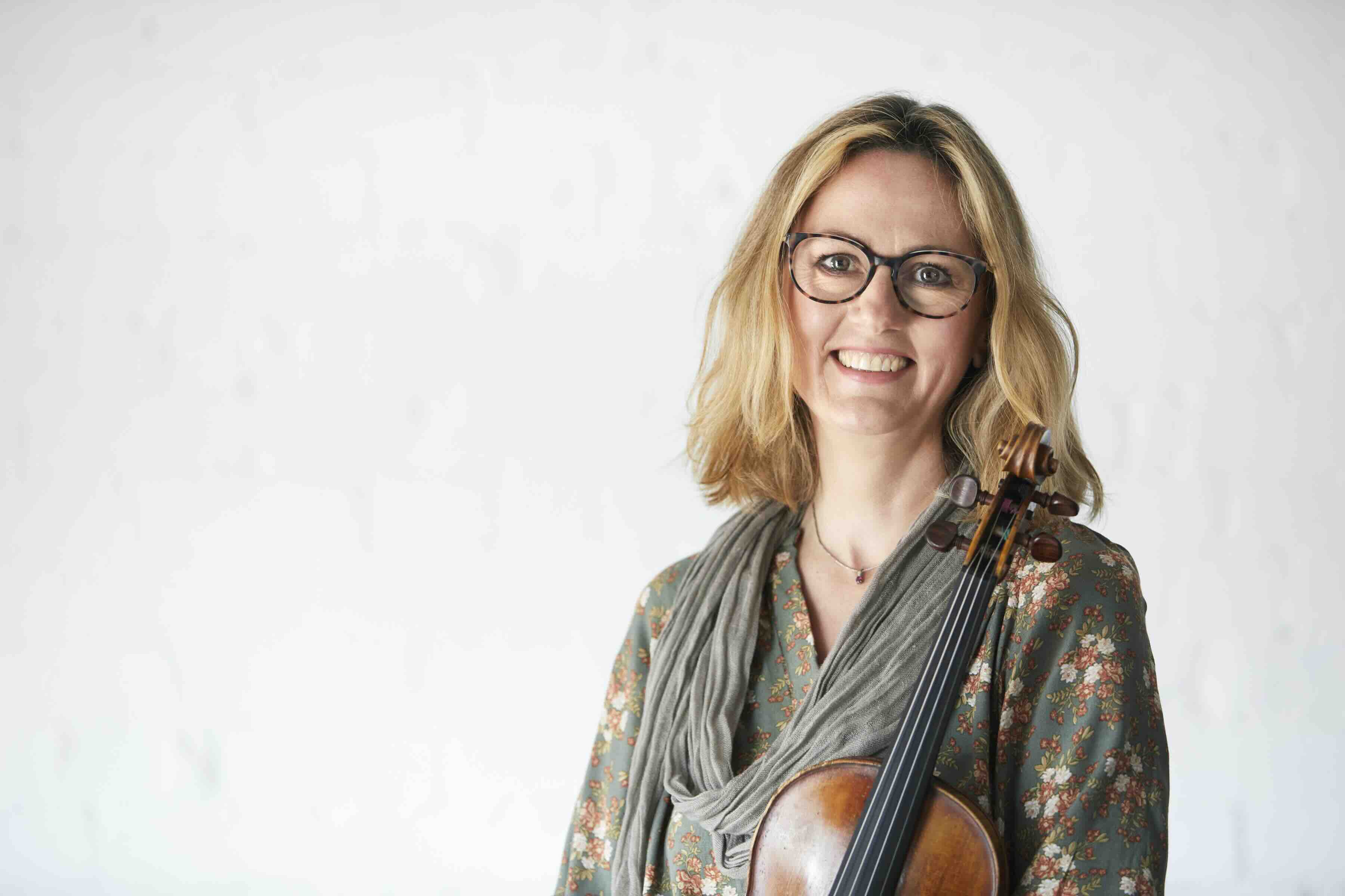 A woman holds a violin