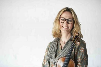 A woman holds a violin