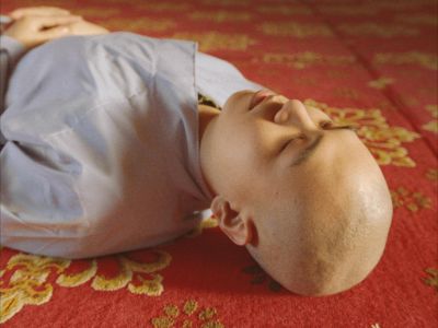 A person lies on a red carpet