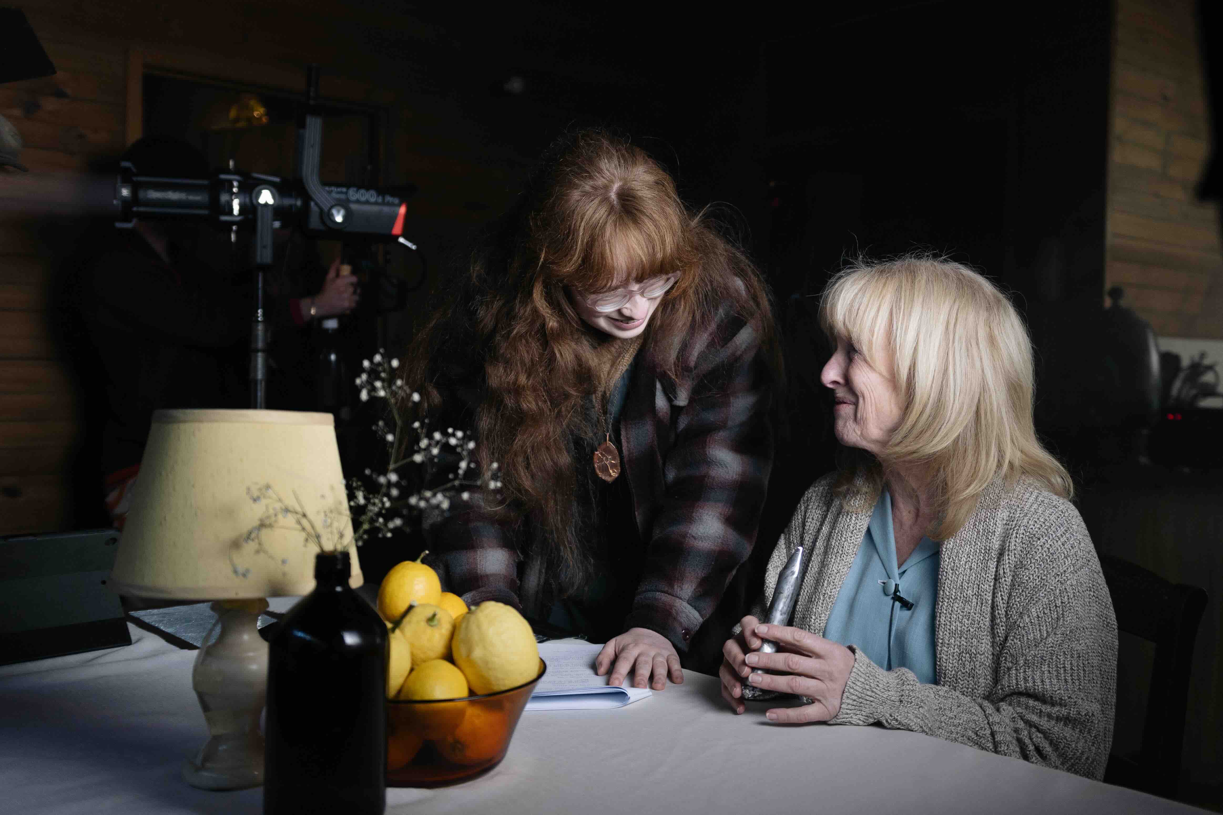 A women stands beside another woman on a film set