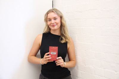 A woman holds a pack of tarot cards