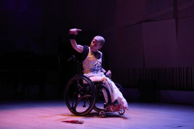 A person in a wheelchair performs on a stage