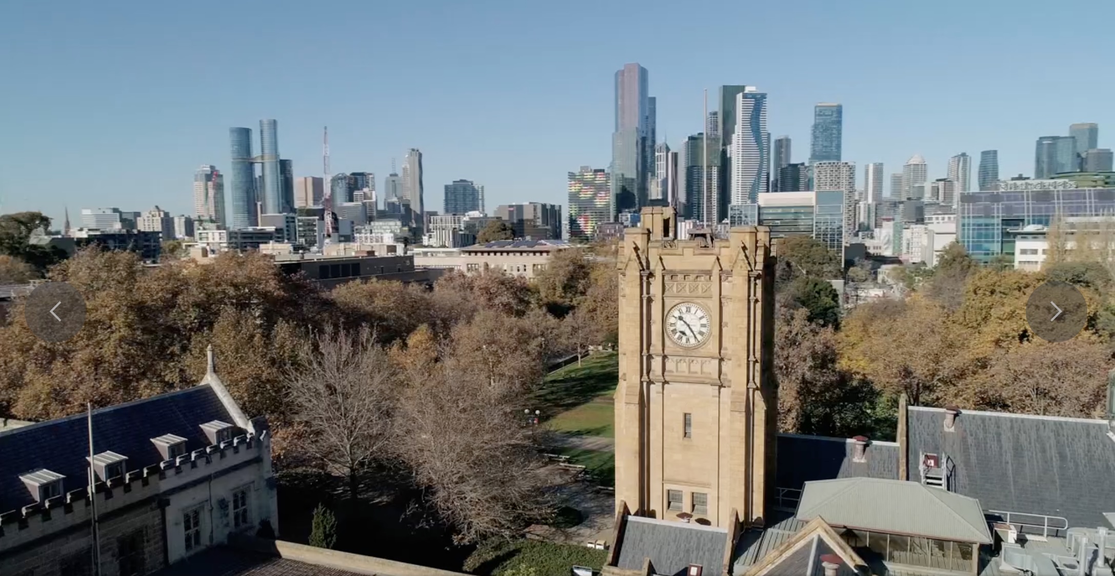 A clocktower with tall buildings in the background