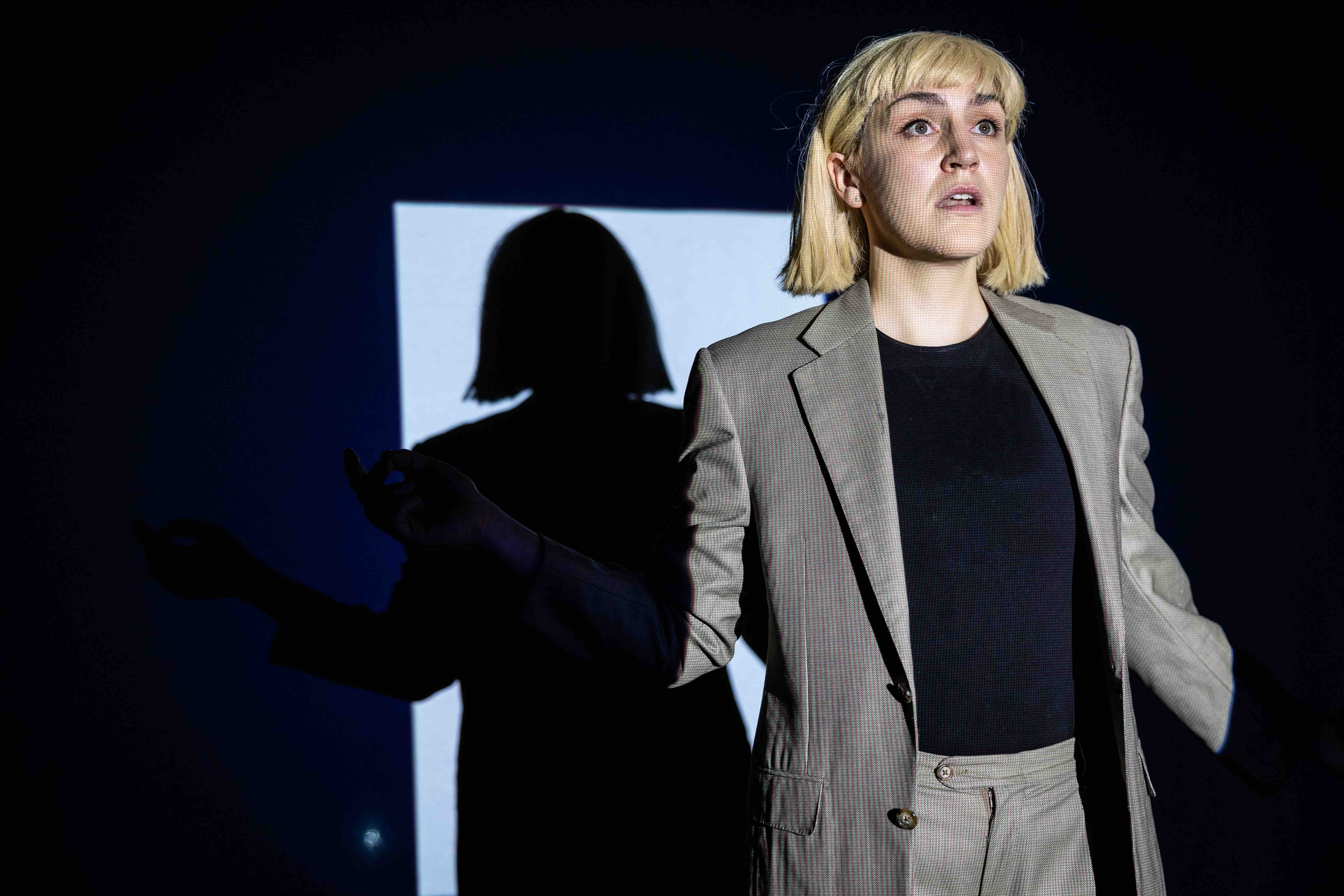 Theatre-maker Mary Angley said receiving a VCA50 Creative Development Grant is a game-changer for their creative practice. Image credit: Jamie Hornsby. A person in a blonde wig stands looking shocked on a dark stage