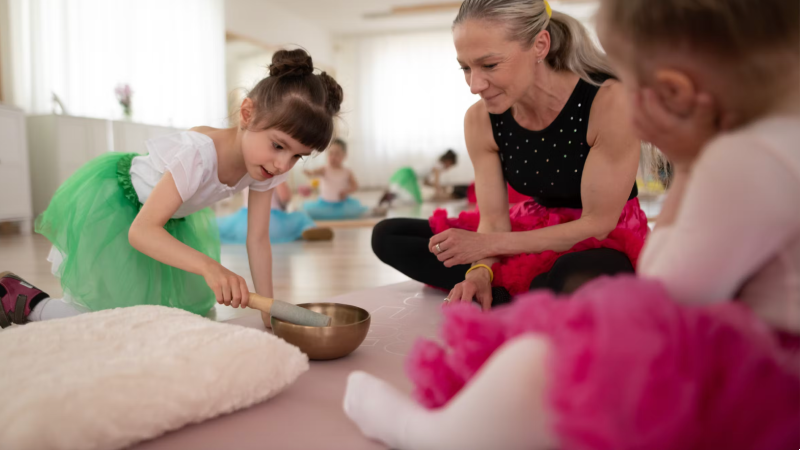 A music therapist sits with two children